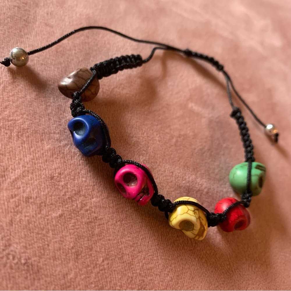 Simple multicolore bracelet with skull and black cord.